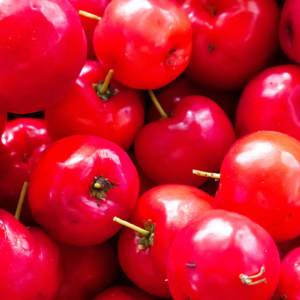 Fotografia autoral de Ricardo Laf mostrando um conjunto de acerolas vermelhas maduras e brilhantes em plano detalhe.