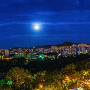 Fotografia noturna em longa exposição de Ricardo Laf, mostrando o movimento das luzes do trânsito no centro de Belo Horizonte com as montanhas ao fundo.
