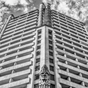 Fotografia em preto e branco de Ricardo Laf mostrando a fachada imponente do Edifício Acaiaca no centro de Belo Horizonte, com foco nas esculturas indígenas e nas linhas Art Déco.