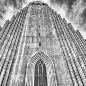 Fotografia em preto e branco de Ricardo Laf capturando a fachada da Igreja Hallgrímskirkja em Reykjavik, Islândia, com foco nas linhas verticais e no céu nublado.