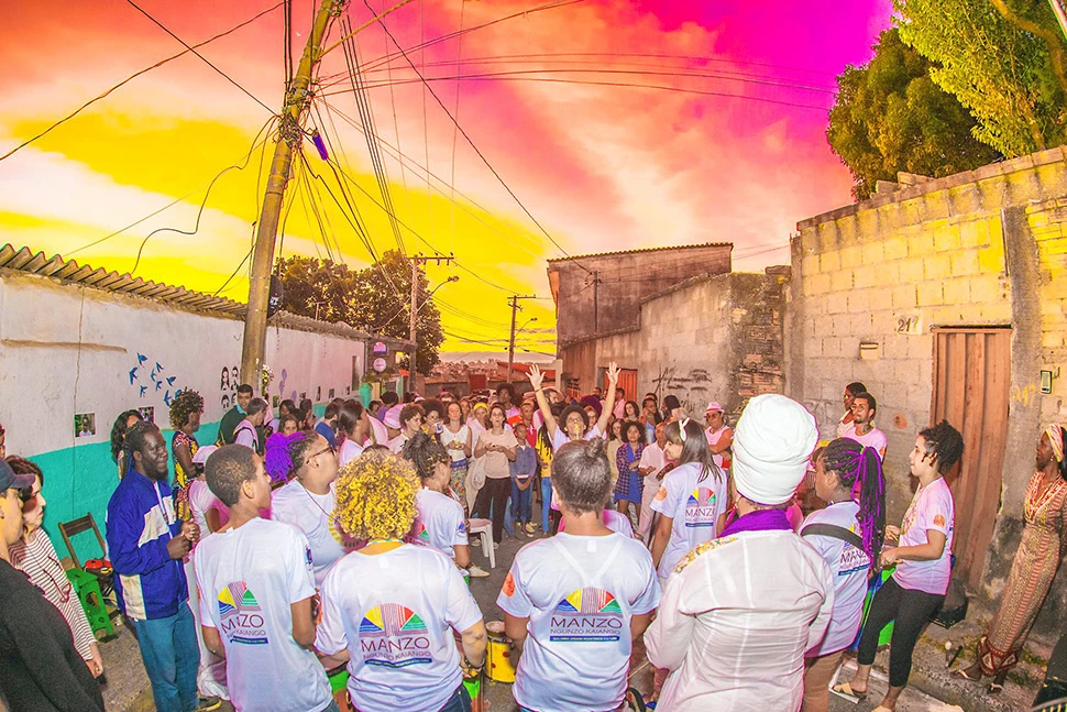 Registro fotográfico de um festejo cultural e religioso no Quilombo Manzo, na região leste de Belo Horizonte, com pessoas em trajes brancos tradicionais, por Ricardo Laf.