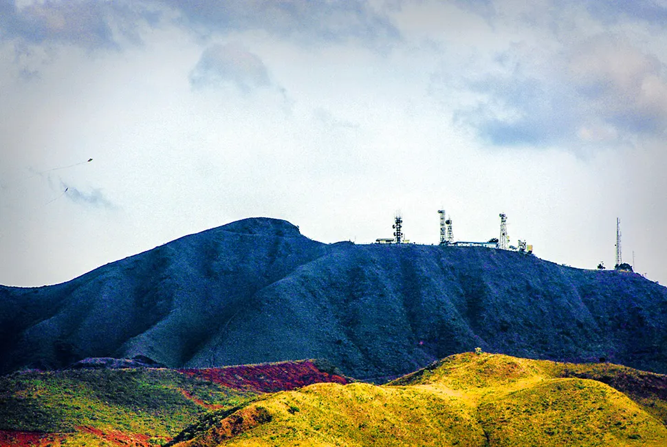 Fotografia de Ricardo Laf capturando o perfil montanhoso da Serra do Curral em Belo Horizonte, destacando as torres de transmissão no topo sob um céu azul claro.