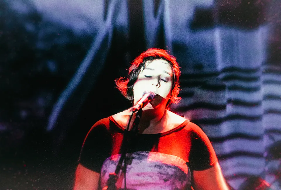 Fotografia de Ricardo Laf apresentando a musicista Juliana Perdigão em um momento de profunda imersão artística no palco, com iluminação dramática e texturas expressivas.