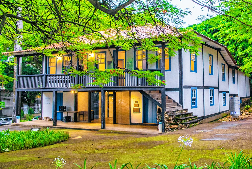 Fotografia de Ricardo Laf do casarão histórico do Museu Abílio Barreto em Belo Horizonte, destacando a arquitetura colonial em contraste com o verde das árvores ao redor.