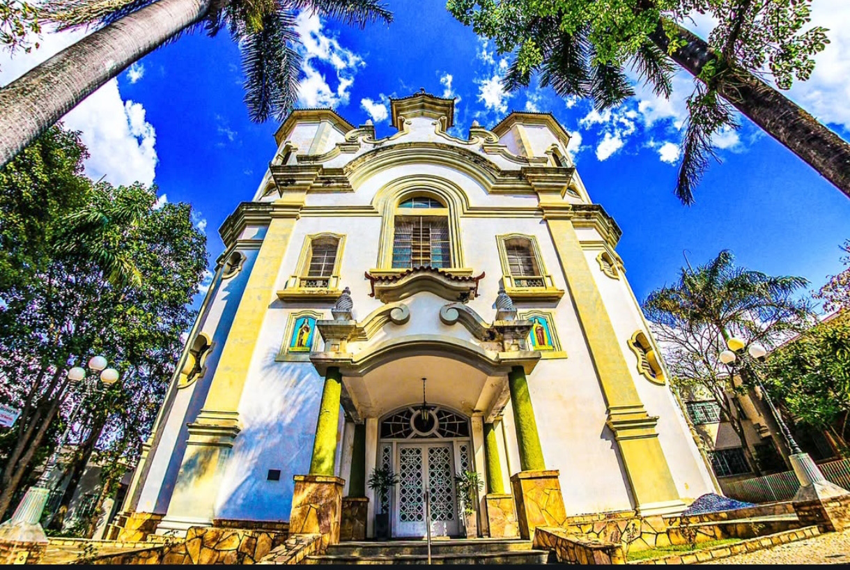 Foto de Ricardo Laf registrando a fachada da Igreja da Paróquia Santa Teresa e Santa Teresinha, construída em 1930 na região leste de Belo Horizonte. A imagem destaca os detalhes arquitetônicos históricos contra o céu azul.