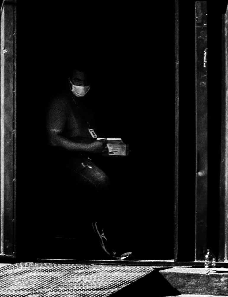Foto de Ricardo Laf capturando um homem de máscara caminhando pelo centro de Belo Horizonte durante a pandemia de coronavírus. A imagem, feita de dentro de um veículo, registra o isolamento social e a nova realidade urbana da capital.