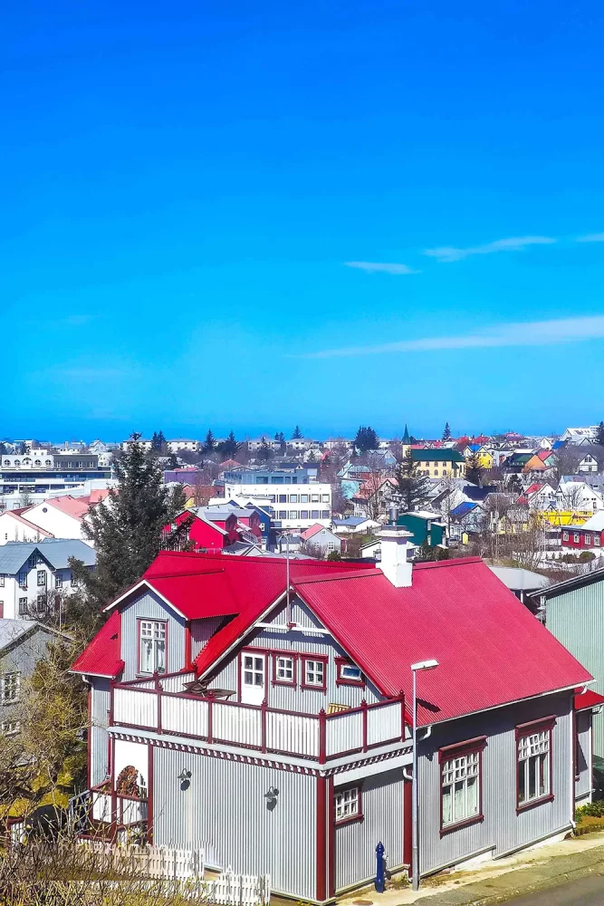 O colorido telhado vermelho de uma residência em Hafnarfjörður, Islândia, em um dia ensolarado, registrado por Ricardo Laf.