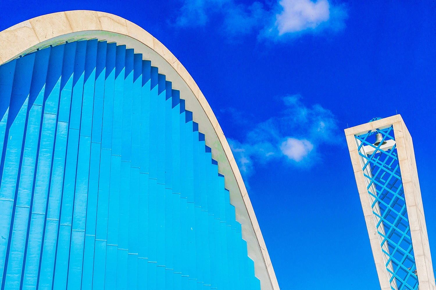 Detalhe em close-up das parábolas em concreto azul e branco da Igreja de São Francisco de Assis na Pampulha sob céu azul.