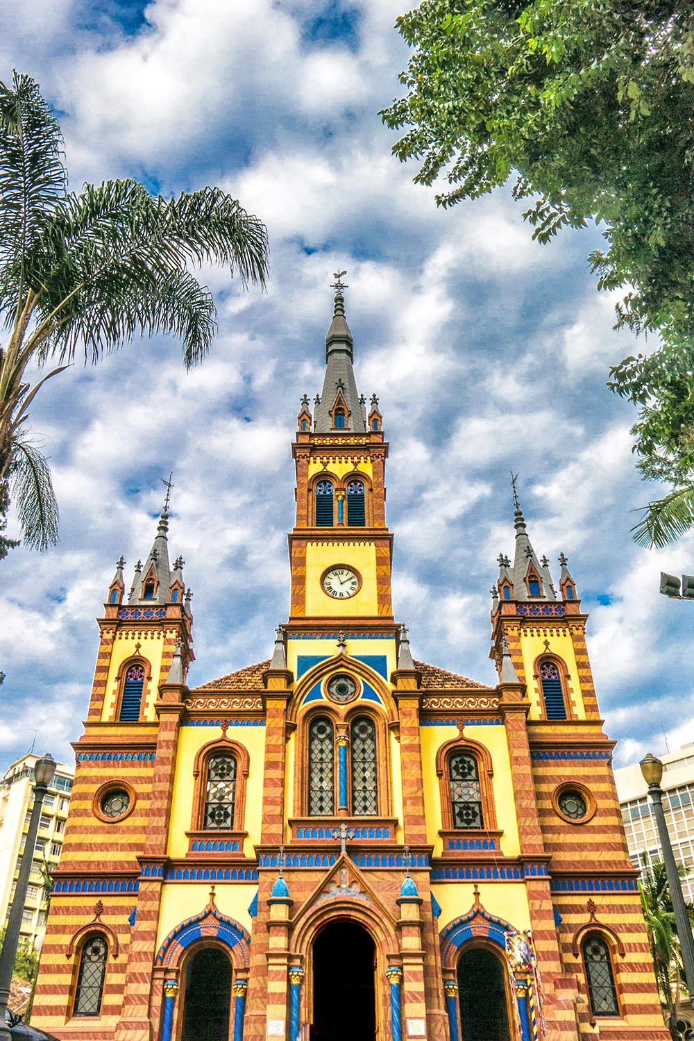 Fachada imponente e detalhada da Igreja São José em estilo neomanuelino, destacando suas torres e vitrais iluminados pelo sol da tarde em Belo Horizonte.