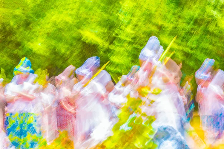 Registro em close-up dos pés e do vestuário colorido em movimento durante a apresentação de Pisada de Caboclo na tradição popular em Belo Horizonte.