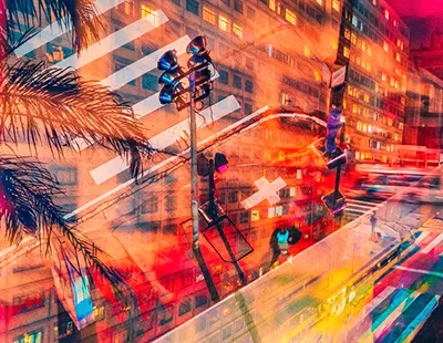 Fotografia em dupla exposição do centro de Belo Horizonte à noite, sobrepondo luzes urbanas, prédios e o tráfego da cidade.